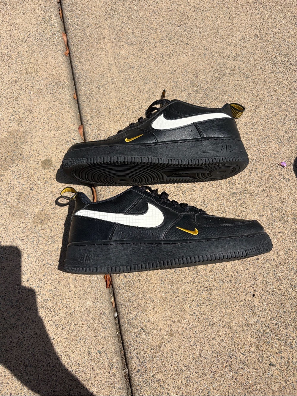 Youth Black Nike Air Force 1s with Textured Swoosh and Gold Accents